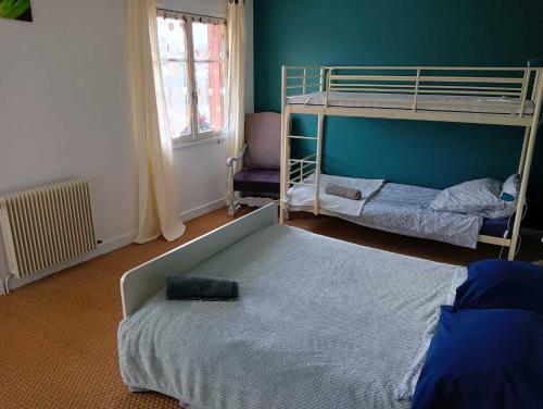 a bedroom with two bunk beds and a window at Gîte à Châtelus, au calme dans l'Allier in Châtelus