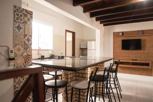 a kitchen with a large island with bar stools at Amplo apto próximo a Praia in Garopaba