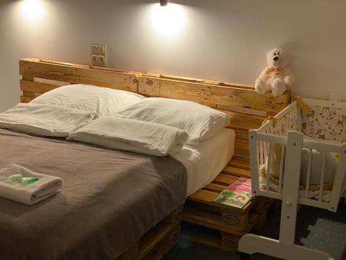 uma cama com um urso de peluche sentado em cima dela em Apartamenty Kajetany 3Rooms em Kajetany