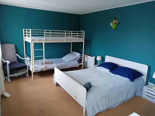 a bedroom with two bunk beds and a blue wall at Gîte à Châtelus, au calme dans l'Allier in Châtelus