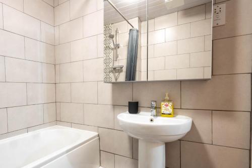 a white bathroom with a sink and a bath tub at Bristol apartment-long stay-April disc-contractors in Bristol
