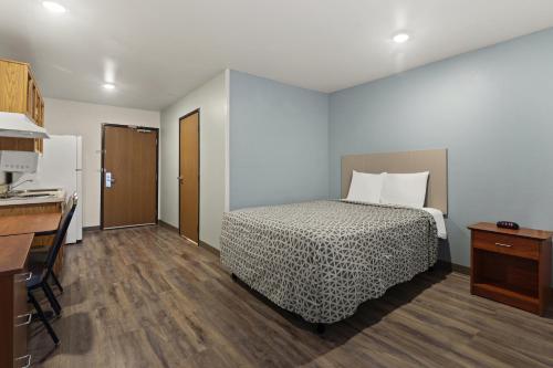 a hotel room with a bed and a kitchen at WoodSpring Suites Columbia Fort Jackson in Royal Pines Estates