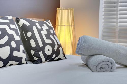 a bed with two pillows and towels on it at 4 Bedrooms Homely House with Garden- Sleeps 9 Comfortably with 6 Comfortable Beds, Free Street Parking, Business Travellers, Contractors, & Holiday-Goers, Coventry, Near All Major Transport Links in Coventry and Motorway in Coventry
