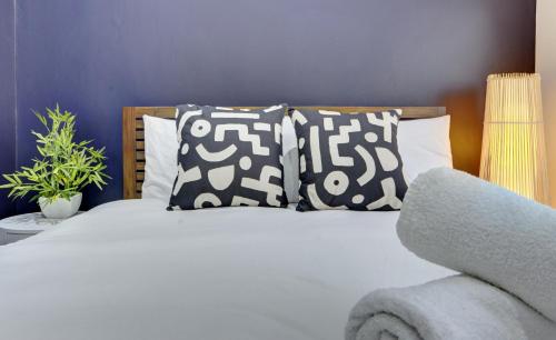 a bedroom with a bed with pillows at 4 Bedrooms Homely House with Garden- Sleeps 9 Comfortably with 6 Comfortable Beds, Free Street Parking, Business Travellers, Contractors, & Holiday-Goers, Coventry, Near All Major Transport Links in Coventry and Motorway in Coventry