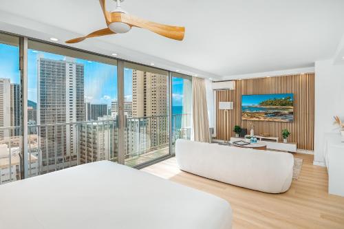 a bedroom with a white bed and large windows at Ocean Retreat: Remodeled Pacific Monarch Haven in Honolulu