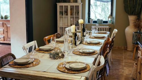 a dining room table with a white table cloth and chairs at Le Mas Fraissinet in Saint-Jean-de-Valériscle