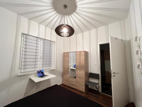 een kamer met een bureau, een raam en een plafond bij Bonvenon in Szombathely