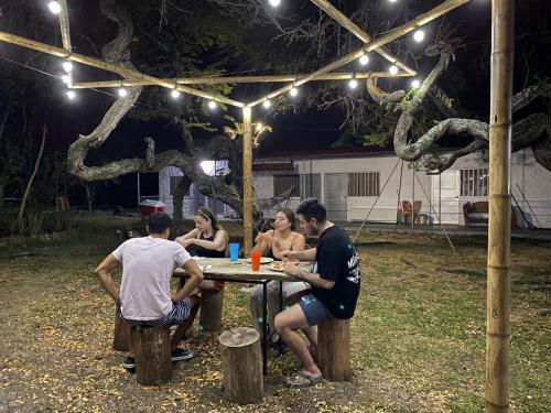 un grupo de personas sentadas en una mesa de picnic por la noche en Ebenezer Ecocamp, en San Francisco