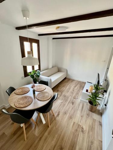 uma sala de estar com uma mesa e cadeiras e um sofá em Acogedor apartamento enfrente de la catedral em Tarragona