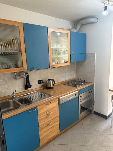 a kitchen with blue cabinets and a sink at Appartamento vista Lago in Lecco
