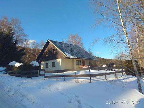 a house with snow on the ground in front of it at Chalupa František Filipovice in Filipovice