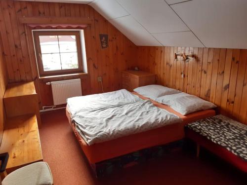 1 dormitorio con cama y banco. en Chalupa František Filipovice, en Filipovice