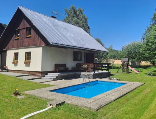 a barn with a swimming pool in front of a house at Chalupa František Filipovice in Filipovice