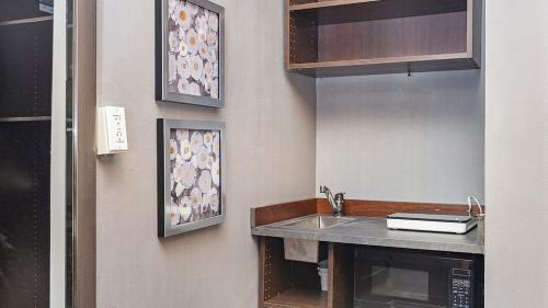 a kitchen with a sink and a mirror at Premier Suites Bay Village in Boston