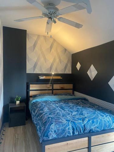 QuaroubleにあるAgréable maison avec parking gratuitのベッドルーム1室(青いベッド1台、シーリングファン付)