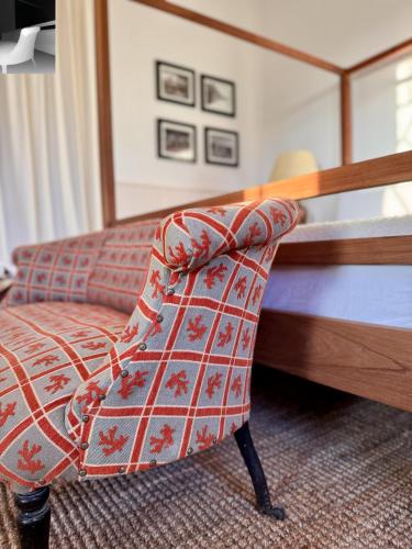 a bedroom with a bed and a red chair at Narbona Wine Lodge in Carmelo