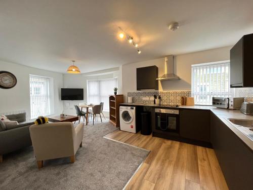 a kitchen and living room with a couch and a table at Eden Corner - 2 Bed in Morecambe