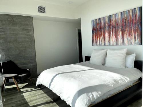 a bedroom with a white bed and a painting on the wall at San Diego Convention Center Padres Ocean Views SD Zoo in San Diego