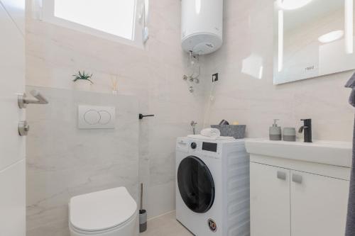 een witte badkamer met een toilet en een wastafel bij Villa Mara in Vrsi