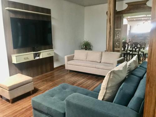 sala de estar con sofá azul y TV en 1-Fantástica casa entre montañas, en Salamina