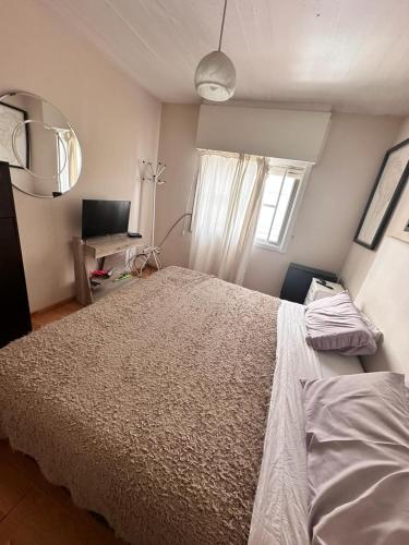 a bedroom with a large bed and a window at Apart Centro in Comodoro Rivadavia