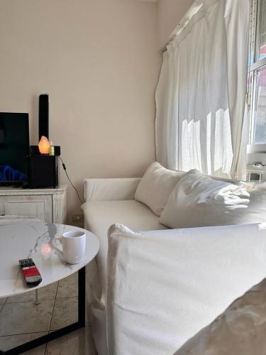 a living room with a white bed and a table at Apart Centro in Comodoro Rivadavia