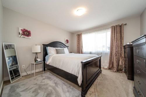 Un dormitorio con una cama grande y una ventana en 3BDRM Home, 5min to WEM/4min to River Cree Casino en Edmonton