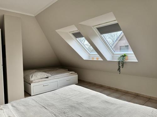 a bedroom with a bed and two windows at Happy Moor in Rellingen