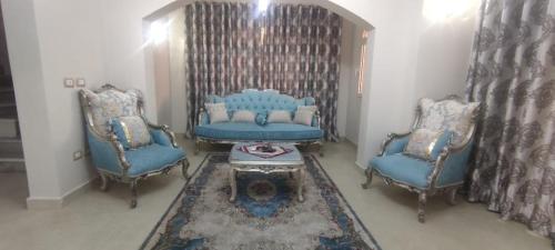 sala de estar con 2 sillas azules y mesa en شرم الشيخ en Alexandría