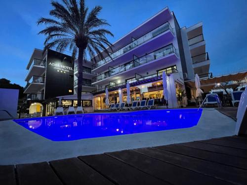 een hotel met een blauw zwembad voor een gebouw bij Adia Hotel Cunit Playa in Cunit