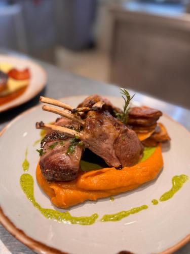 a plate of food with meat and vegetables on a table at Narbona Wine Lodge in Carmelo