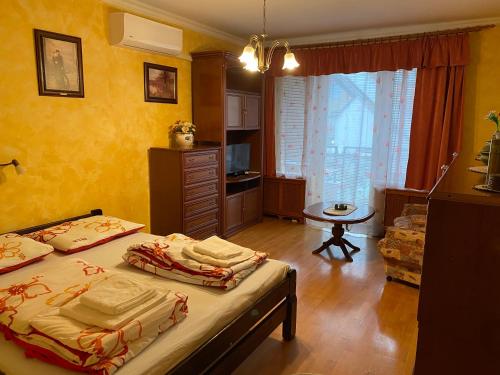 een slaapkamer met 2 bedden in een kamer met gele muren bij Hévíz Tavirózsa Apartman in Hévíz