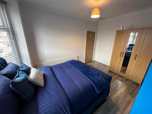 a bedroom with a blue bed and a wooden floor at Modern Guest House in Etruria