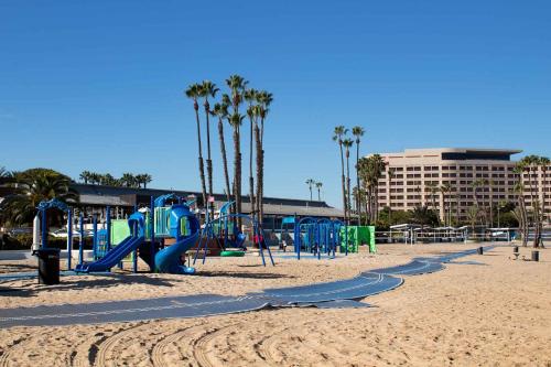 a playground on a beach with palm trees and a building at Venice Beach Lux Retreat Coastal Apartment Haven in Los Angeles
