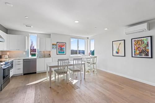 a kitchen with white cabinets and a table and chairs at Back to The Future Sweet Suites in Seattle