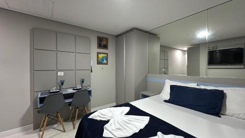 a bedroom with a bed and a desk and a tv at 16- Studio Decorado perfeito para casal!!! in Curitiba