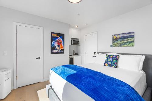 a white bedroom with a blue blanket on a bed at Back to The Future Sweet Suites in Seattle