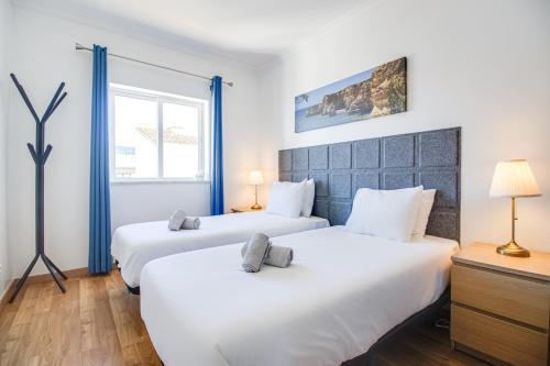 2 białe łóżka w pokoju z oknem w obiekcie Old Town 2BR 50m Ocean w/ AC Wi-Fi Parking Terrace w Albufeirze