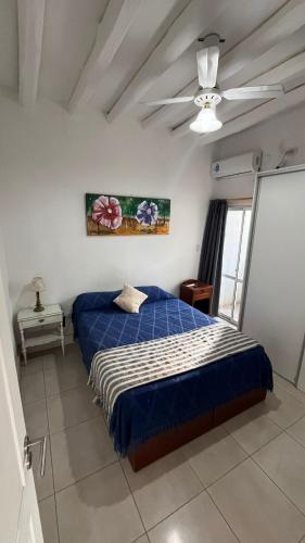 una camera con letto blu e ventilatore a soffitto di Tierras del Malbec 1 a Ciudad Lujan de Cuyo