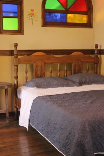 聖何塞的住宿－Cabina de montaña，卧室内的一张床铺,设有彩色玻璃窗