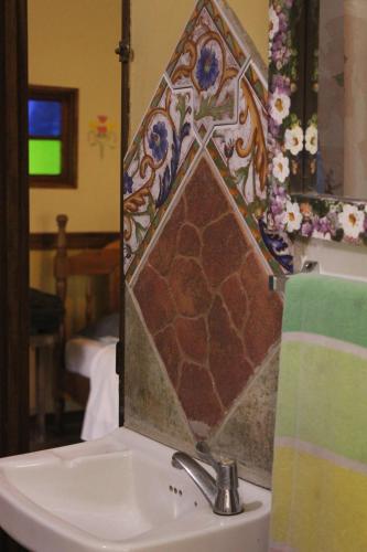 a bathroom with a sink with a tile on the mirror at Cabina de montaña in San José