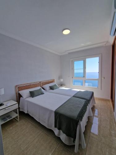 um quarto com uma cama grande e uma janela em Villa Costa em Santa Cruz de Tenerife