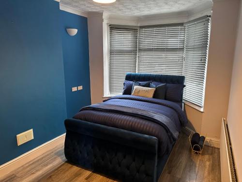 a blue bedroom with a bed and a window at Modern Guest House in Etruria