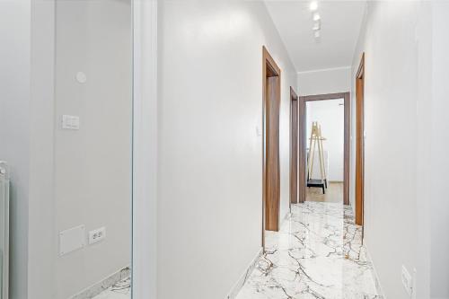 a hallway with white walls and marble floors at Apartment Delton in Fažana