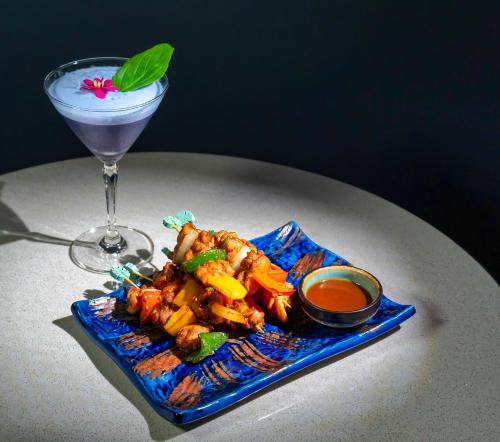 a plate of food and a drink on a table at Mercure Bangkok Surawong in Bangkok