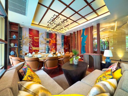 a restaurant with couches and a tables and chairs at Mercure Bangkok Surawong in Bangkok
