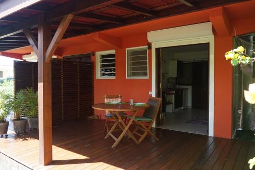 a patio with a table and chairs on a deck at Caraibe Créol' Keys in Port-Louis