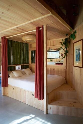 - une chambre avec 2 lits dans une maison en bois dans l'établissement L'îlot du 9 - Cabane & spa au bord du lac, à Hourtin