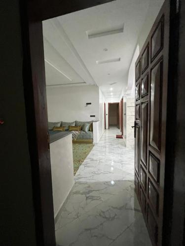 a room with a hallway with a bed and a door at شقة تتوفر على جميع شروط الراحة و الامان in Benguerir