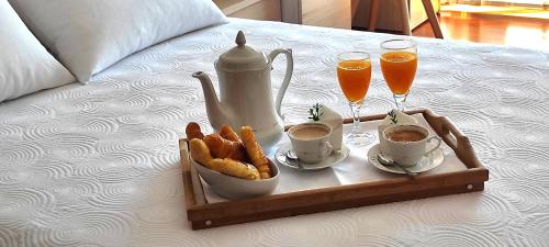 a tray with a tea set and drinks on a bed at Luan in Moaña